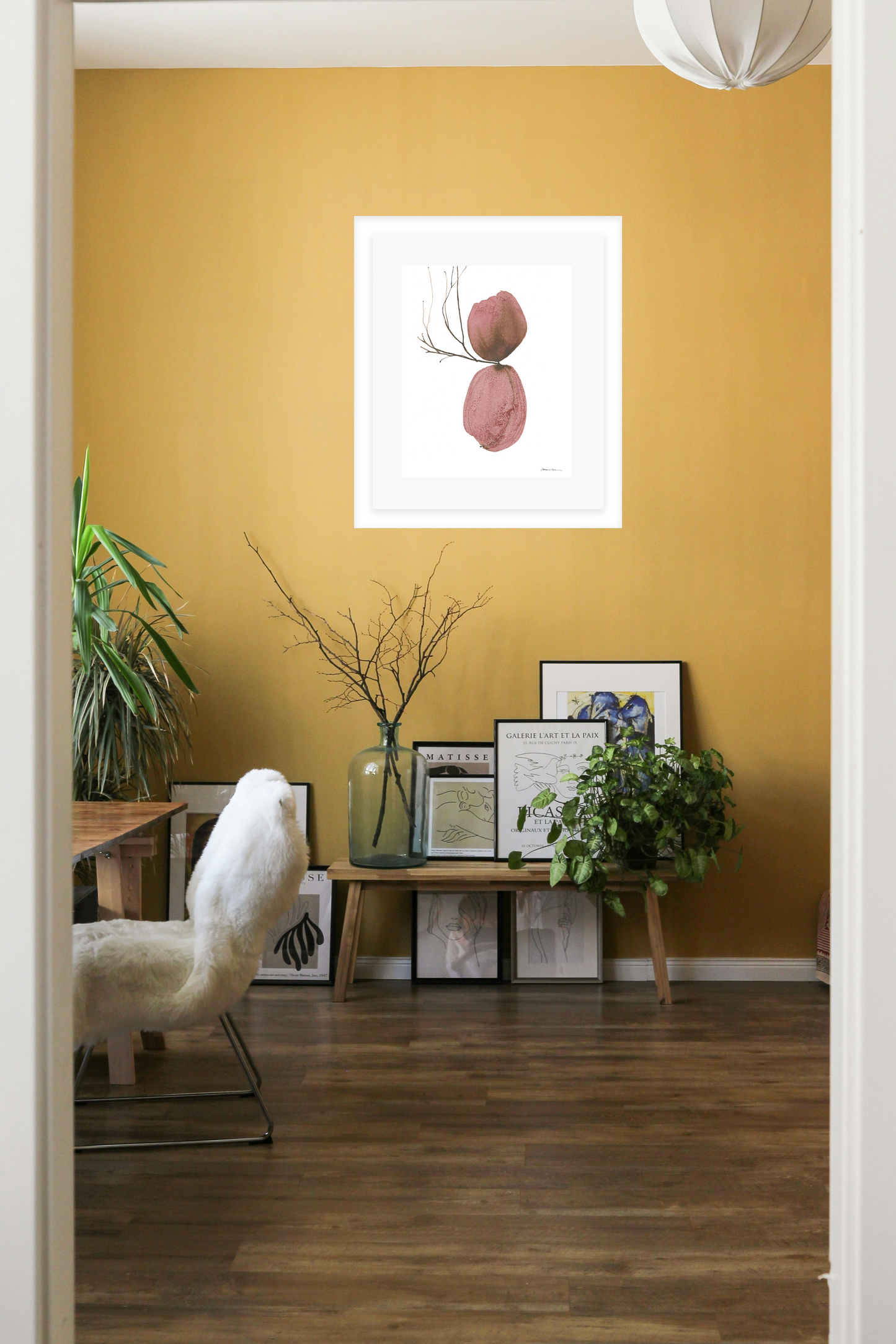 Living room with a yellow wall, framed artwork, and decorative items.