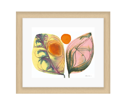 Framed artwork of two colorful leaves with a white background in a light wood frame