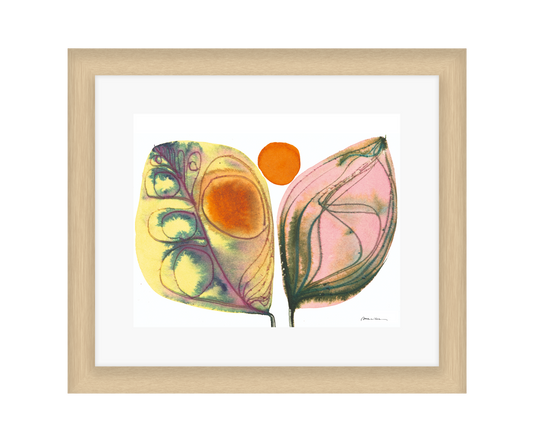 Framed artwork of two colorful leaves with a white background in a light wood frame