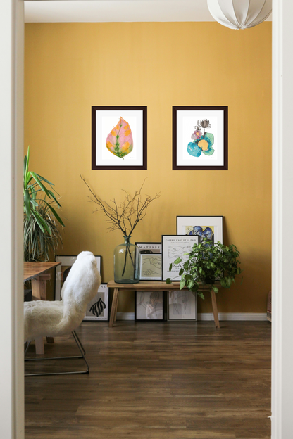 Living room with yellow walls, framed artwork, and a white armchair.