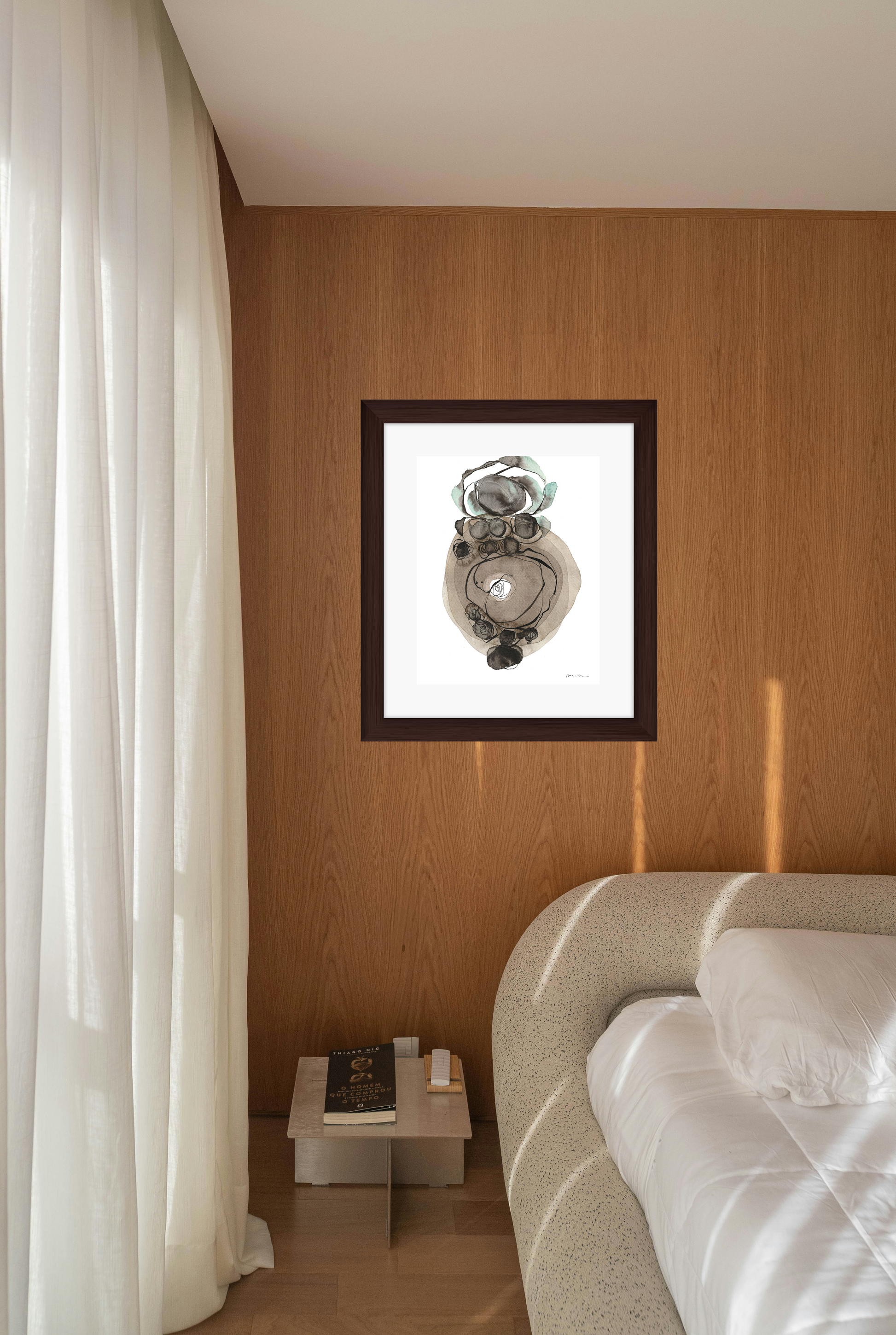 Framed artwork on a wall above a bed in a bedroom setting